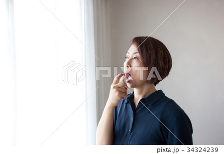 喉スプレーをするミドル女性 34324239