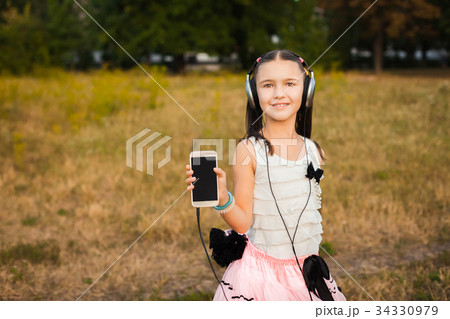 little girl showing her smartphone with headphones little girl showing her smartphone with headphones 34330979