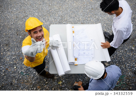 Engineering team look paper plans by top view 34332559