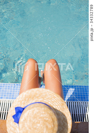 Beautiful girl in a hat near a blue pool - sun Beautiful girl in a hat near a blue pool - sun 34332789