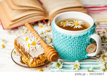 Honeycomb and chamomile tea on white 34334807