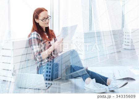 Serious woman in glasses reading an important 34335609