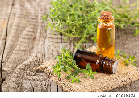Bottle of essential oil with herbs thyme on an old 34336103