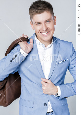 fashion young man in blue suit carrying leather 34337135
