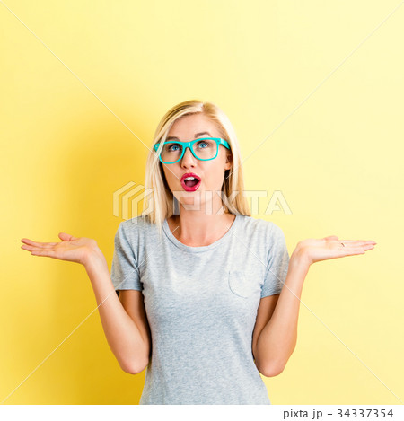 Young woman with glasses shrugging on 34337354