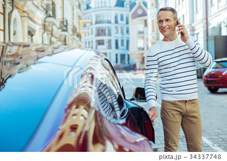 Joyful nice man opening the door of his car Joyful nice man opening the door of his car 34337748