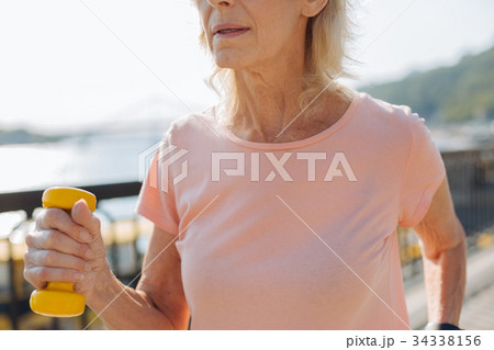 Close up of elderly female holding yellow Close up of elderly female holding yellow 34338156