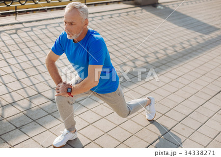 Athletic senior man warming up before morning run Athletic senior man warming up before morning run 34338271