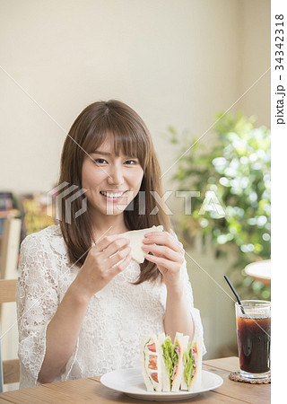サンドイッチを食べる女性の写真素材