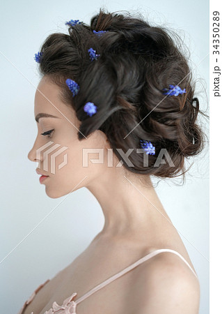 Beautiful young woman with blue muscari in her hair Beautiful young woman with blue muscari in her hair 34350289