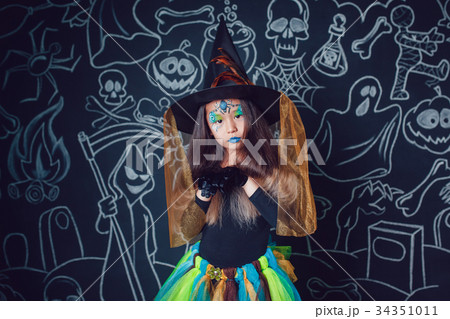 Girl in a witch costume on dark background with 34351011