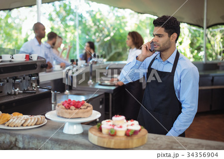 Waiter talking on mobile phone Waiter talking on mobile phone 34356904