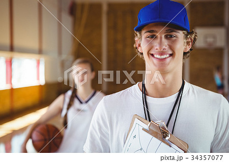 Portrait of smiling male coach with basketball player 34357077