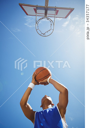 Directly below shot of teenage boy playing basketball Directly below shot of teenage boy playing basketball 34357177