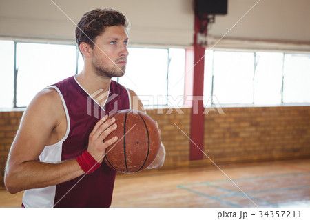 Man practicing basketball in court 34357211