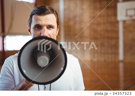 Portrait of male coach using megaphone 34357323