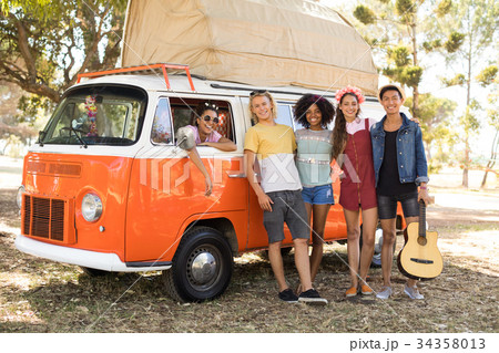 Portrait of smiling friends standing by camper van Portrait of smiling friends standing by camper van 34358013