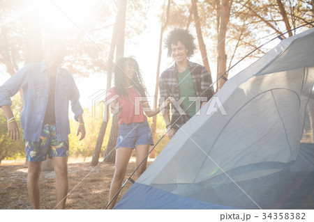 Happy friends standing by tent 34358382