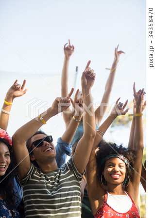 Happy fans dancing with arms raised during music festival Happy fans dancing with arms raised during music festival 34358470