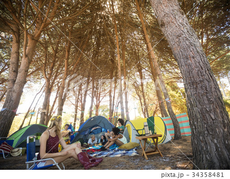 Friends sitting together at campsite 34358481
