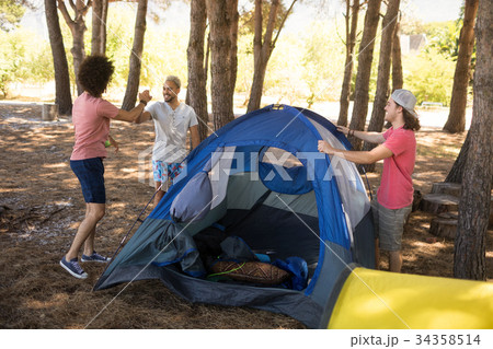 Smiling friends preparing tent Smiling friends preparing tent 34358514