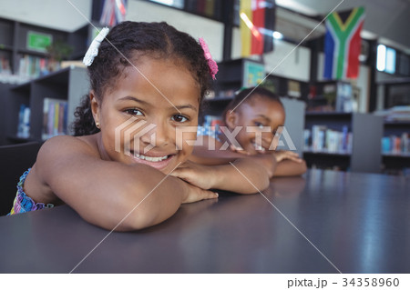 Portrait of smiling girls leaning on desk 34358960