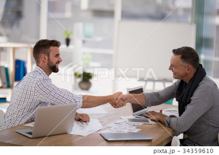 Business partners shaking hands in the office Business partners shaking hands in the office 34359610