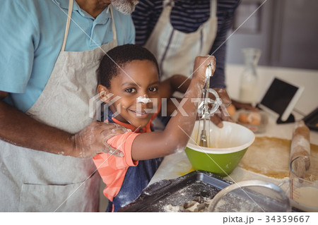 Boy learning to whisk the eggs while preparing cookies 34359667