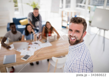 Smiling male executive standing in the office 34360022
