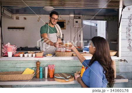 Smiling waiter giving wrap to customer Smiling waiter giving wrap to customer 34360176