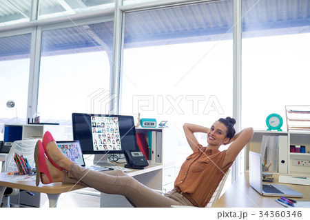 Female executive relaxing at her desk Female executive relaxing at her desk 34360346