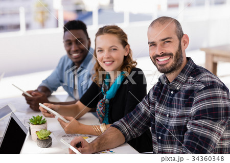 Happy executives using digital table in conference room Happy executives using digital table in conference room 34360348