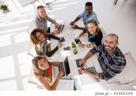 Portrait of happy colleagues sitting at conference table 34360349