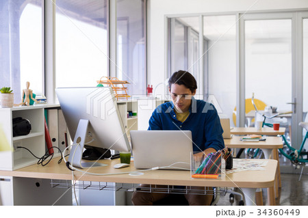 Male executive working over laptop at his desk Male executive working over laptop at his desk 34360449