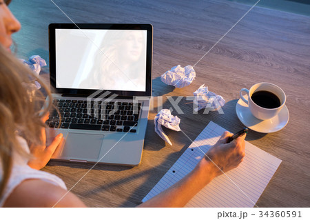 Female executive writing on paper at her desk 34360591