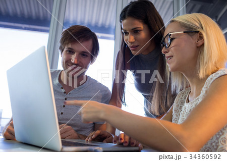 Executives discussing over laptop during a meeting 34360592