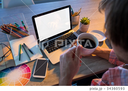 Male executive working over laptop at his desk Male executive working over laptop at his desk 34360593