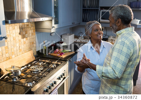 High angle view of couple dancing in kitchen High angle view of couple dancing in kitchen 34360872