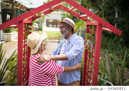 Smiling senior couple standing face to face Smiling senior couple standing face to face 34360951