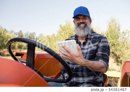 Portrait of happy man using digital tablet in tractor Portrait of happy man using digital tablet in tractor 34361467