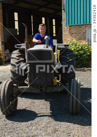 Attentive worker driving a tractor 34362416