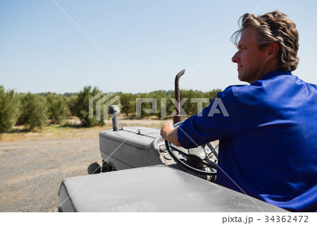Attentive worker driving a tractor 34362472