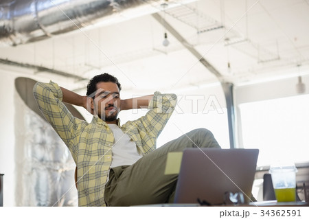 Relaxed man sitting on chair in office Relaxed man sitting on chair in office 34362591