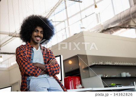 Portrait of smiling man with curly hair at office Portrait of smiling man with curly hair at office 34362826