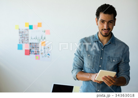 Portrait of man using tablet at office Portrait of man using tablet at office 34363018