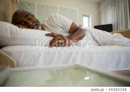 Senior man sleeping on bed in the bedroom Senior man sleeping on bed in the bedroom 34363198
