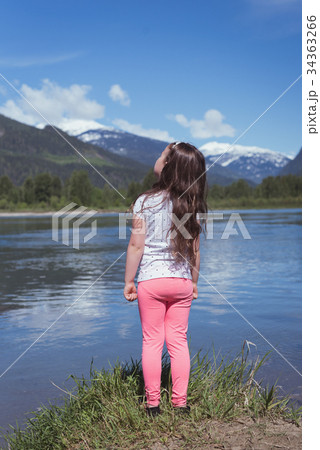 Rear view of girl standing near river 34363266