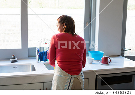 Woman washing utensil in kitchen sink Woman washing utensil in kitchen sink 34363325