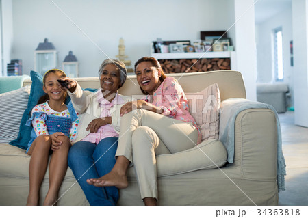 Smiling family watching television together in living room 34363818