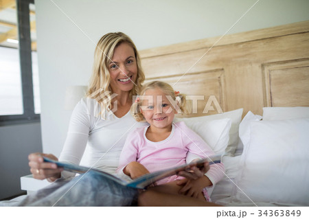 Mother and daughter reading story book in the bedroom Mother and daughter reading story book in the bedroom 34363849